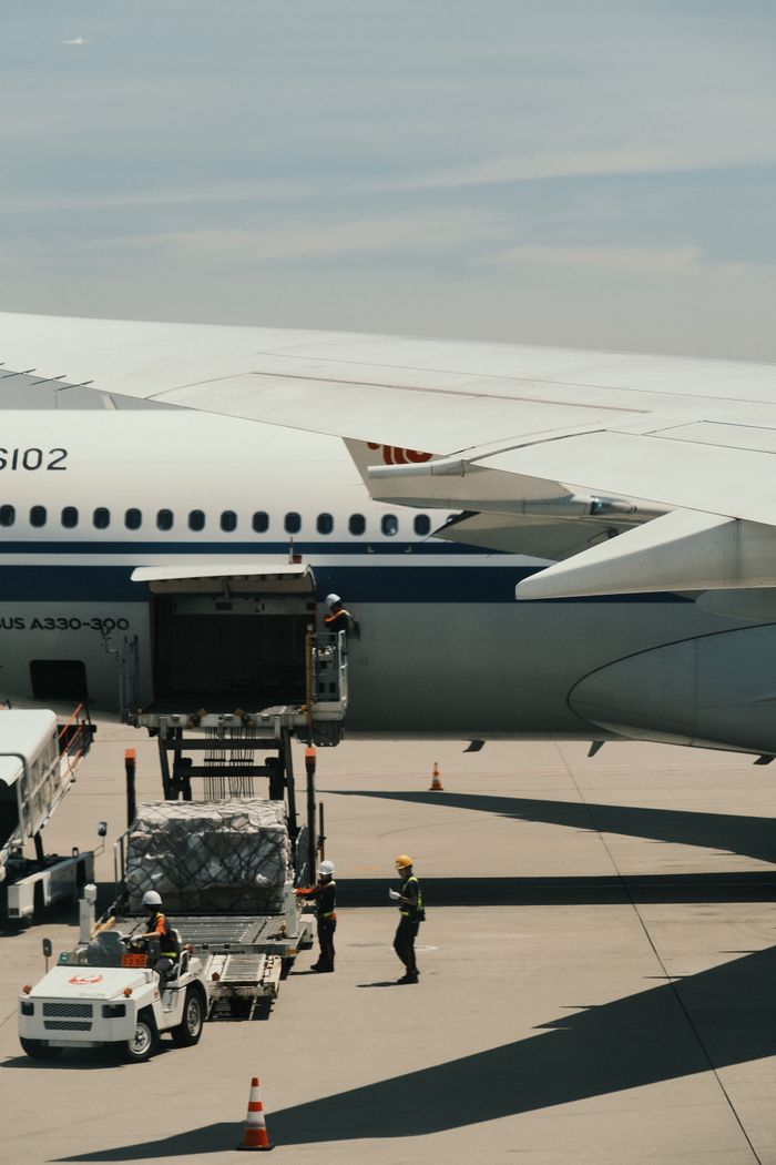 services-01 Airbus A330 being loaded with cargo on an airport runway, showcasing transportation logistics.