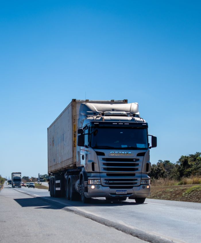 services-01 A large cargo truck travels on a highway in Brazil under clear blue skies.