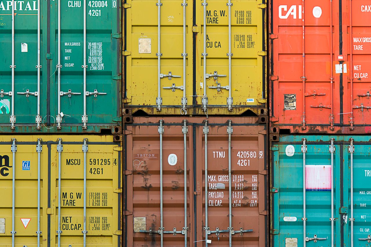 our-services-1 Vibrant cargo containers stacked in a shipping yard highlighting global trade.